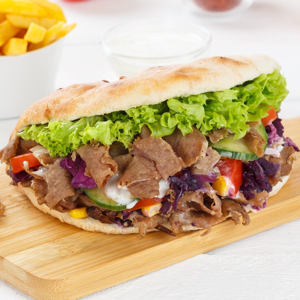 Aziz Hot Chicken & Kebab's doner kebab with meat, lettuce, red cabbage, cucumber, and tomato.