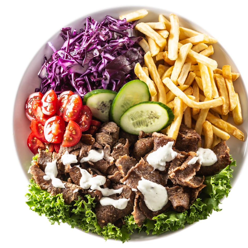 Aziz Hot Chicken & Kebab plate with kebab meat, fries, red cabbage, tomatoes, cucumbers, and lettuce.